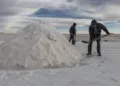 Employees shovel salt into mountains at the Salar de Uyuni (Uyuni Salt Flats) in Potosi, Bolivia, on Sunday, Dec. 11, 2016. Bolivia has the largest lithium deposits of any country, which are estimated to be about half of the world's supply. Photographer: Marcelo Perez del Carpio/Bloomberg