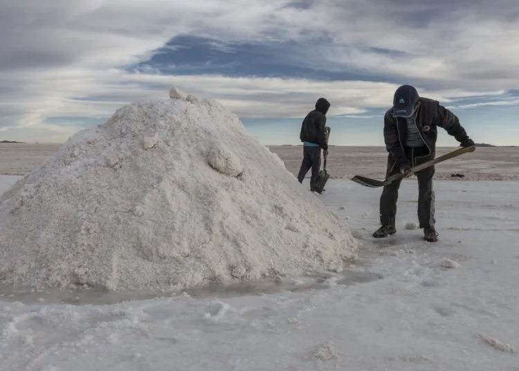 Employees shovel salt into mountains at the Salar de Uyuni (Uyuni Salt Flats) in Potosi, Bolivia, on Sunday, Dec. 11, 2016. Bolivia has the largest lithium deposits of any country, which are estimated to be about half of the world's supply. Photographer: Marcelo Perez del Carpio/Bloomberg