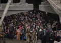 Ukrainians crowd under a destroyed bridge as they try to flee crossing the Irpin river in the outskirts of Kyiv, Ukraine, Saturday, March 5, 2022. (AP Photo/Emilio Morenatti)