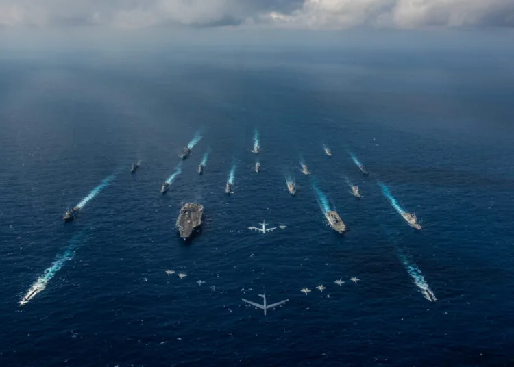 FILE PHOTO: The aircraft carrier USS Ronald Reagan and the Japan Maritime Self-Defense Force helicopter destroyer JS Hyuga sail in formation with 16 other ships from the U.S. Navy and the Japan Maritime Self-Defense Force as aircraft from the U.S. Air Force and Japan Air Self-Defense Force fly overhead in formation during Keen Sword in the Philippine Sea November 8, 2018. Courtesy Kaila V. Peters/U.S. Navy/Handout via REUTERS/File Photo. ATTENTION EDITORS - THIS IMAGE HAS BEEN SUPPLIED BY A THIRD PARTY. To match Special Report TAIWAN-CHINA/SUBMARINES