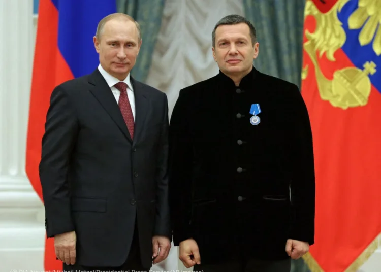 In this photo taken Wednesday, Dec. 25, 2013, Russian President Vladimir Putin, left, and Russian television and radio host Vladimir Solovyov pose for a photo during an awards ceremony in Moscow's Kremlin. (AP Photo/RIA Novosti, Mikhail Metzel, Presidential Press Service)