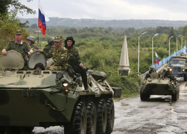 Russian soldiers sit atop armored vehicles as they cross a bridge over the Inguri River as Russian troops pull out from an area outside Georgia's breakaway province of Abkhazia, Wednesday, Oct. 8, 2008. Moscow must withdraw its troops from buffer zones surrounding the two regions by Friday under cease-fire agreements brokered by French President Nicolas Sarkozy in the wake of the August war. (AP Photo/Vladimir Popov)