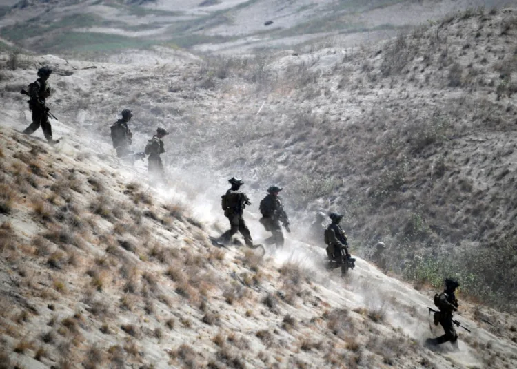 Los Marines de EE.UU. descienden una duna de arena tras un ejercicio de fuego real contra una fuerza de "invasión" imaginaria como parte de los ejercicios militares anuales conjuntos Balikatan entre EE.UU. y Filipinas. AFP / Ted Aljibe