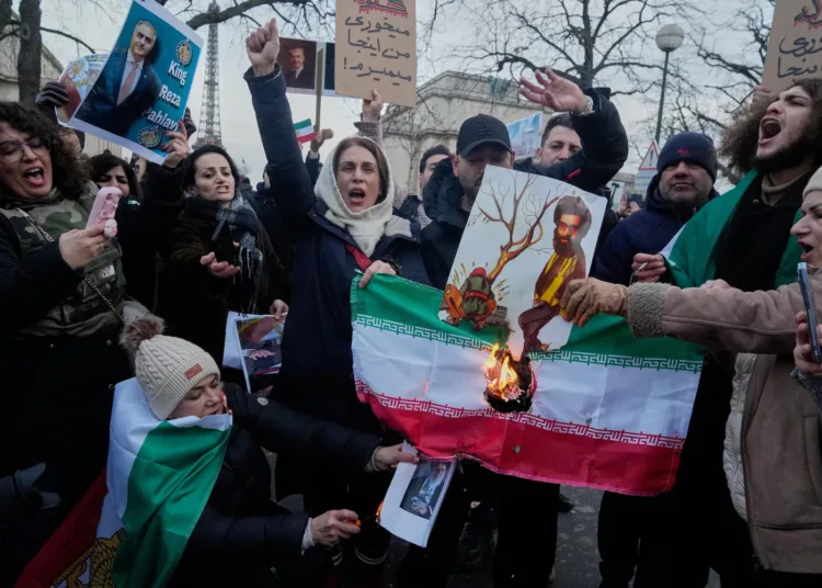 Manifestantes queman la bandera nacional iraní durante una manifestación en apoyo a las manifestaciones masivas a nivel nacional en Irán contra el gobierno en París, el domingo 11 de enero de 2026.