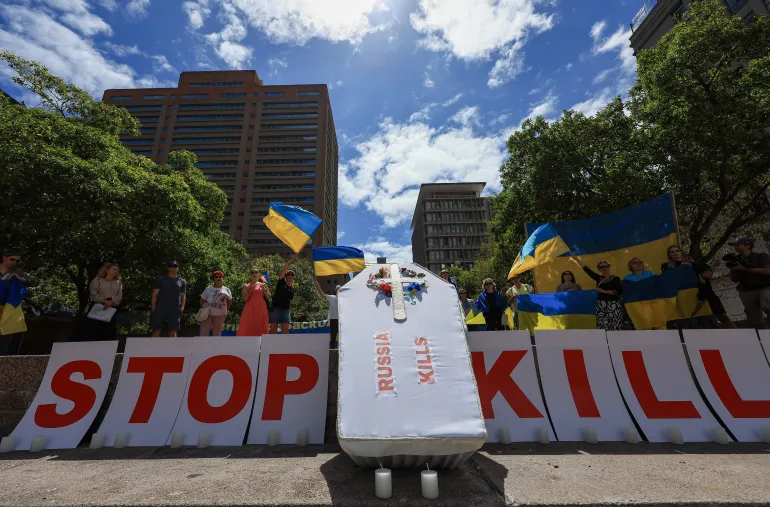 Partidarios de Ucrania protestan detrás de un ataúd simulado frente al consulado ruso para conmemorar los cuatro años desde la invasión de Ucrania, en medio del ataque de Rusia a Ucrania, en Ciudad del Cabo, Sudáfrica, el 24 de febrero de 2026/ Créditos: Esa Alexander/Reuters.