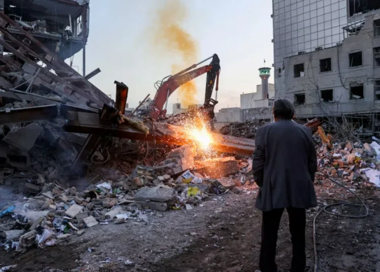 Hombre mira una estación de policía destruida por un bombardeo de Estados Unidos e Israel en Irán