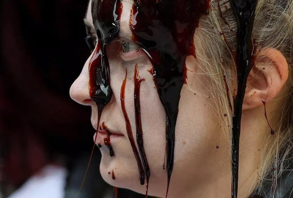 Un líquido que simula un combustible fósil resbala por los rostros de los manifestantes durante una protesta de «Fossil Free London» contra la dependencia del petróleo, en un contexto de subida de los precios del crudo y mientras continúa el conflicto entre Estados Unidos e Israel con Irán, frente a la embajada de Estados Unidos en Londres, Reino Unido. Créditos: REUTERS/ Hannah McKay