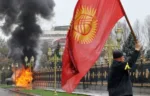A Kyrgyz opposition supporter waves the national flag near the main government building during an anti-government protest in Bishkek on April 7, 2010. Opposition followers killed Kyrgyzstan's interior minister, took the deputy prime minister hostage and captured state television in a deadly revolt against President Kurmanbek Bakiyev. A source in the office of Interior Minister Moldomus Kongantiyev revealed that he had been killed in riots in the northwest hub of Talas where the first protests had erupted. AFP PHOTO / VYACHESLAV OSELEDKO