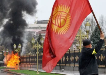 A Kyrgyz opposition supporter waves the national flag near the main government building during an anti-government protest in Bishkek on April 7, 2010. Opposition followers killed Kyrgyzstan's interior minister, took the deputy prime minister hostage and captured state television in a deadly revolt against President Kurmanbek Bakiyev. A source in the office of Interior Minister Moldomus Kongantiyev revealed that he had been killed in riots in the northwest hub of Talas where the first protests had erupted. AFP PHOTO / VYACHESLAV OSELEDKO