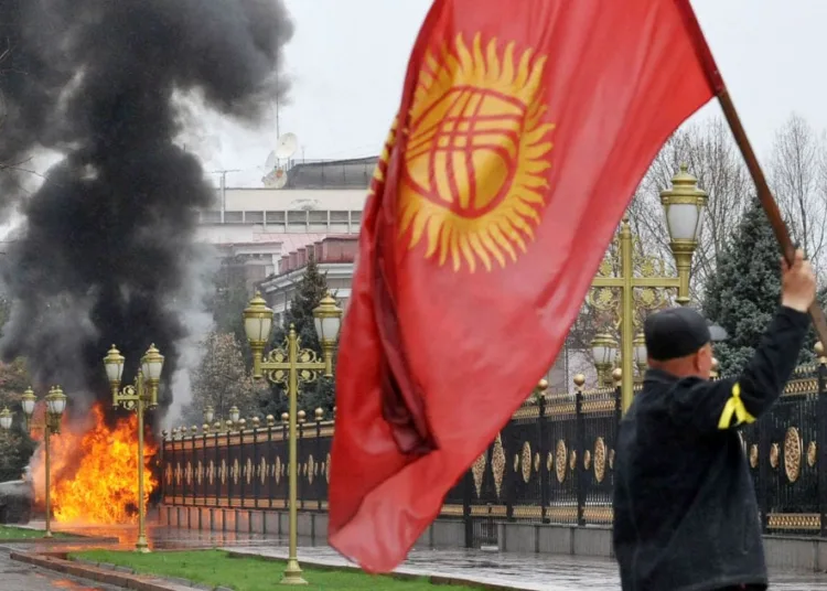 A Kyrgyz opposition supporter waves the national flag near the main government building during an anti-government protest in Bishkek on April 7, 2010. Opposition followers killed Kyrgyzstan's interior minister, took the deputy prime minister hostage and captured state television in a deadly revolt against President Kurmanbek Bakiyev. A source in the office of Interior Minister Moldomus Kongantiyev revealed that he had been killed in riots in the northwest hub of Talas where the first protests had erupted. AFP PHOTO / VYACHESLAV OSELEDKO