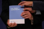 COP25 High Level Climate Champion Gonzalo Munoz holds the copy of The Paris Agreement as he poses with Britain's former Minister of State for Energy and Clean Growth and newly appointed COP26 President, Claire Perry, Italian Environment Minister Sergio Costa and Spanish State Secretary of Environment Hugo Moran (not pictured) during the U.N. Climate Change Conference (COP25) in Madrid, Spain December 13, 2019. REUTERS/Susana Vera