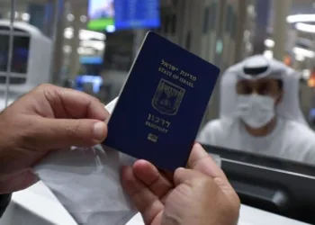 An Israeli man presents his passport for control upon arrival from Tel Aviv to the Dubai airport in the United Arab Emirates, on November 26, 2020, on the first scheduled commercial flight operated by budget airline flydubai, following the normalisation of ties between the UAE and Israel. (Photo by Karim SAHIB / AFP)