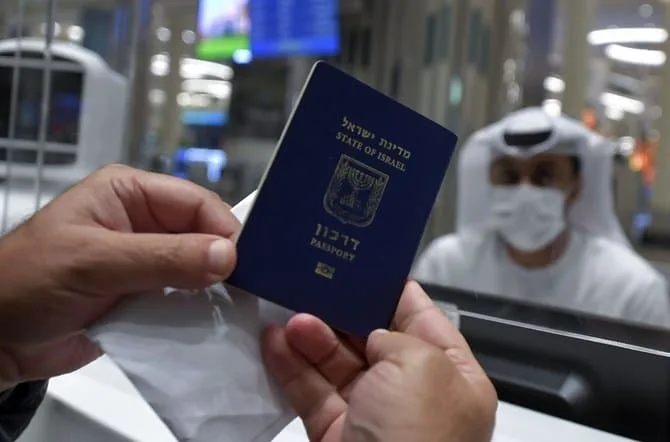 An Israeli man presents his passport for control upon arrival from Tel Aviv to the Dubai airport in the United Arab Emirates, on November 26, 2020, on the first scheduled commercial flight operated by budget airline flydubai, following the normalisation of ties between the UAE and Israel. (Photo by Karim SAHIB / AFP)