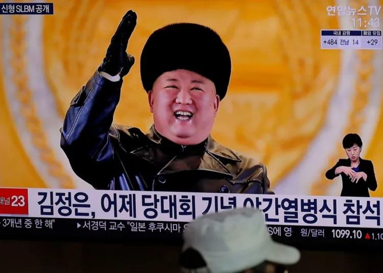 A man wearing a face mask sits in front of a TV screen showing North Korean leader Kim Jong Un, at the Seoul Railway Station in Seoul, South Korea, Jan. 15, 2021.