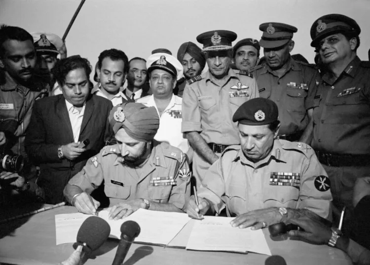 At the Dacca Race Course, Gen. Jagjit Singh Aurora (left), Chief of Staff of the Indian Army, and General Amir Abdullah Khan Niazi of the Pakistani Army sign the papers that would end the war between the two countries and lead to the creation of Bangladesh. (Photo by Bettmann via Getty Images)