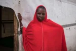 Hafsa Oumar, refugiada nigeriana de 16 años, se apoya en la puerta de un aula en el campamento de Dar es Salam, en la región del Lago Chad. Hafsa se matriculó en la escuela por primera vez cuando llegó a Chad, pero dejó de asistir a clases después de casarse. Fuente: UNICEF