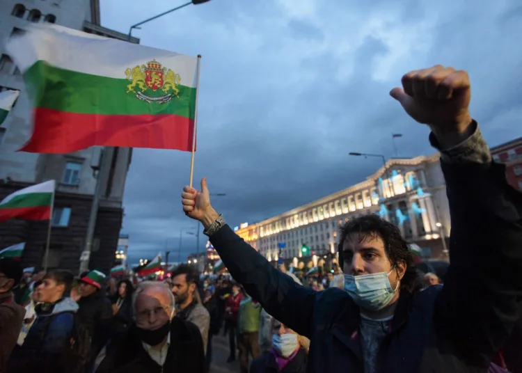 People shout slogans and wave Bulgarian flags during an anti-government protest near the parliament building in Sofia on October 16, 2020. - On the 100th day of protests in Sofia on October 16, several thousand people gathered to demand the resignation of Prime Minister Boyko Borisov and his conservative cabinet as well as the country's chief prosecutor. (Photo by Dimitar Kyosemarliev / AFP) (Photo by DIMITAR KYOSEMARLIEV/AFP via Getty Images)