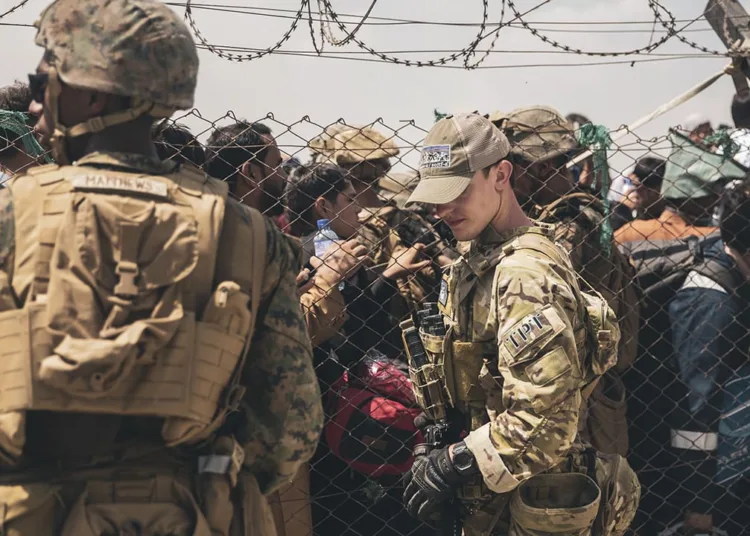 In this Aug. 22, 2021, photo provided by the U.S. Marines, U.S. service members provide assistance during an evacuation at Hamid Karzai International Airport in Kabul, Afghanistan. (Staff Sgt. Victor Mancilla/U.S. Marine Corps via AP)