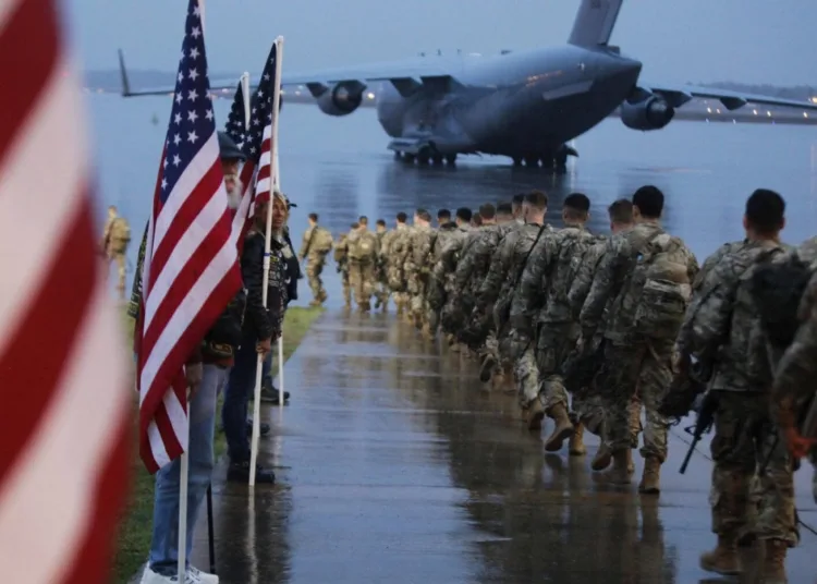 FILE - In this Saturday, Jan. 4, 2020, file photo, this photo provided by the U.S. Army, paratroopers assigned to 1st Brigade Combat Team, 82nd Airborne Division walk as they prepare equipment and load aircraft bound for the U.S. Central Command area of operations from Fort Bragg, N.C. A push led by pro-Iran factions to oust U.S. troops from Iraq is gaining momentum, bolstered by a Parliament vote in favor of a bill calling on the the government to remove them. But the path forward is unclear. (Spc. Hubert Delany III/U.S. Army via AP, File)