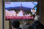People watch a TV screen showing a news program reporting about North Korea's missile launch with file footage at a train station in Seoul, South Korea, Tuesday, Oct. 19, 2021. North Korea fired a ballistic missile into the sea on Tuesday in a continuation of its recent weapons tests, the South Korean and Japanese militaries said, hours after the U.S. reaffirmed its offer to resume diplomacy on the North's nuclear weapons program. Korean letters read: on the top of screen read: "Fired a ballistic missile." (AP Photo/Lee Jin-man)