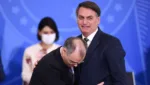 (FILES) In this file photo taken on April 29, 2020 Brazilian President Jair Bolsonaro (R) is embraced by his new Justice Minister Andre Mendonca during the latter's inauguration at Planalto Palace in Brasilia. - Brazilian President Jair Bolsonaro announced on July 12, 2021 that he will appoint his former Justice Minister Andre Mendonca, a Presbyterian pastor, to a vacant position in the Supreme Court, fulfilling his promise to impose a "terribly evangelical" judge in the highest court." (Photo by EVARISTO SA / AFP)