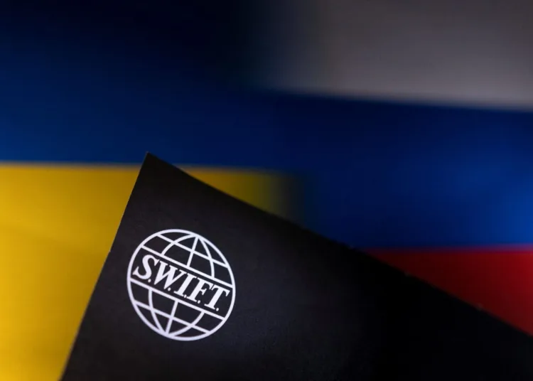 Swift logo is placed on Ukrainian's and Russian's flag colors in this illustration taken, Bosnia and Herzegovina, February 25, 2022. REUTERS/Dado Ruvic/Illustration