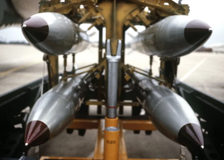 A front view of four nuclear free-fall bombs on a bomb cart.