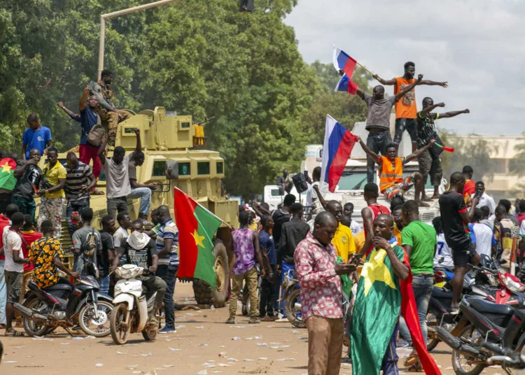 Supporters of Capt. Ibrahim Traore cheer with Russian flags in the streets of Ouagadougou, Burkina Faso, Sunday, Oct. 2, 2022. Burkina Faso's new junta leadership is calling for calm after the French Embassy and other buildings were attacked. (AP Photo/Kilaye Bationo)