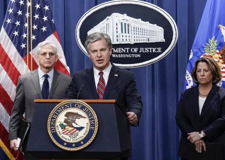 FBI Director Christopher Wray, center, flanked by Attorney General Merrick Garland, left, and Deputy Attorney General Lisa Monaco, speaks to reporters as they announce charges against two men suspected of being Chinese intelligence officers for attempting to obstruct a U.S. criminal investigation and prosecution of Chinese tech giant Huawei, at the Department of Justice in Washington, Monday, Oct. 23, 2022. (AP Photo/J. Scott Applewhite)