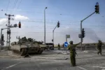 An Israeli army soldier directs an approaching Puma armoured personnel carrier (APC) moving near the Gaza border in southern Israel on October 14, 2023. Thousands of people, both Israeli and Palestinians have died since October 7, 2023, after Palestinian Hamas militants entered Israel in a surprise attack leading Israel to declare war on Hamas in the Gaza Strip enclave on October 8. (Photo by Aris MESSINIS / AFP) (Photo by ARIS MESSINIS/AFP via Getty Images)