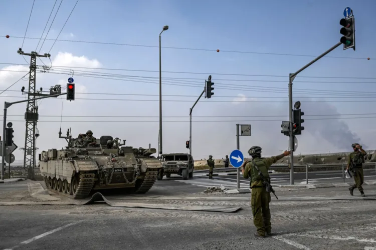An Israeli army soldier directs an approaching Puma armoured personnel carrier (APC) moving near the Gaza border in southern Israel on October 14, 2023. Thousands of people, both Israeli and Palestinians have died since October 7, 2023, after Palestinian Hamas militants entered Israel in a surprise attack leading Israel to declare war on Hamas in the Gaza Strip enclave on October 8. (Photo by Aris MESSINIS / AFP) (Photo by ARIS MESSINIS/AFP via Getty Images)