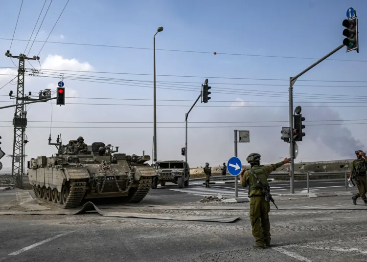 An Israeli army soldier directs an approaching Puma armoured personnel carrier (APC) moving near the Gaza border in southern Israel on October 14, 2023. Thousands of people, both Israeli and Palestinians have died since October 7, 2023, after Palestinian Hamas militants entered Israel in a surprise attack leading Israel to declare war on Hamas in the Gaza Strip enclave on October 8. (Photo by Aris MESSINIS / AFP) (Photo by ARIS MESSINIS/AFP via Getty Images)