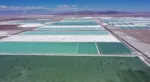 Aerial view of brine ponds and processing areas of the lithium mine of the Chilean company SQM (Sociedad Quimica Minera) in the Atacama Desert, Calama, Chile, on September 12, 2022. - The turquoise glimmer of open-air pools meets the dazzling white of a seemingly endless salt desert where hope and disillusionment collide in Latin America's "lithium triangle." A key component of batteries used in electric cars, demand has exploded for the "white gold" found in Argentina, Bolivia and Chile in quantities larger than anywhere else in the world. (Photo by Martin BERNETTI / AFP)