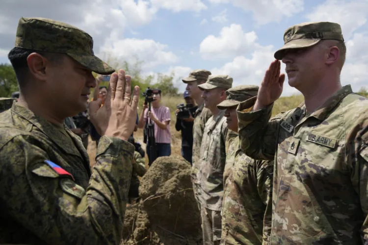 El comandante militar filipino Anthony Coronel (i) frente a soldados estadounidenses en la provincia Nueva Ecija, en el norte de Filipinas, el 31 de marzo de 2023. (Foto AP /Aaron Favila)