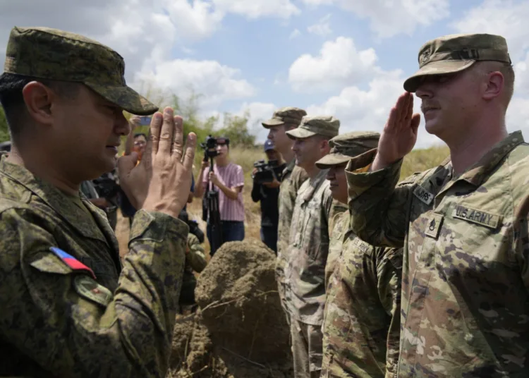 El comandante militar filipino Anthony Coronel (i) frente a soldados estadounidenses en la provincia Nueva Ecija, en el norte de Filipinas, el 31 de marzo de 2023. (Foto AP /Aaron Favila)