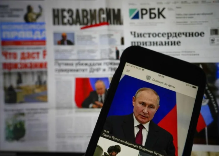 The app of the Russian government newspaper is displayed on an iPhone screen showing Russian President Vladimir Putin during his speech in the Kremlin in Moscow, Russia, Tuesday, Feb. 22, 2022. As the West sounds the alarm about the Kremlin ordering troops into eastern Ukraine and decries an invasion, Russian state media paints a completely different picture. It portrays the move as Moscow coming to the rescue of war-torn areas tormented by Ukraine’s aggression and bringing them much-needed peace. (AP Photo/Alexander Zemlianichenko Jr)