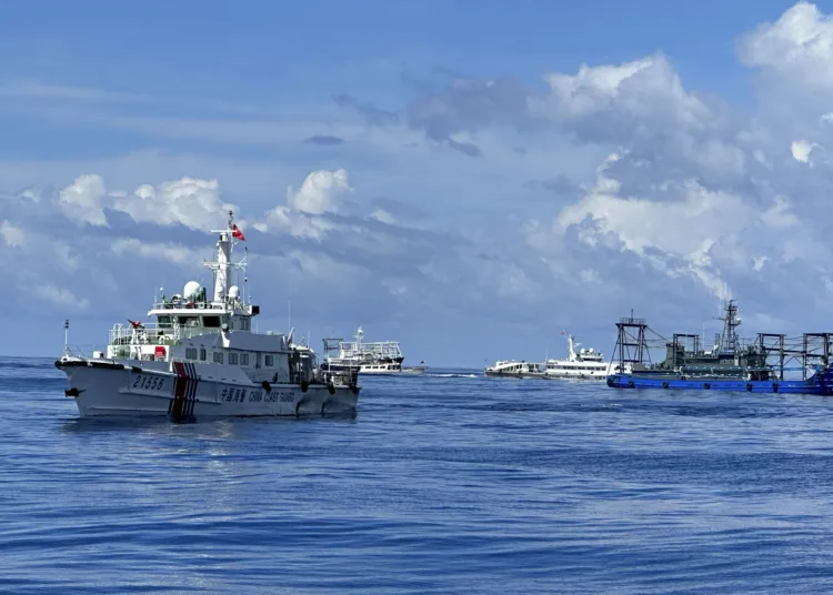 La guardia costera china y una embarcación china bloquean el paso a un barco de la guardia costera filipina mientras se acerca al banco de arena Ayingin, en el disputado Mar de China Meridional, el viernes 10 de noviembre de 2023. (AP Foto/Joeal Calupitan)