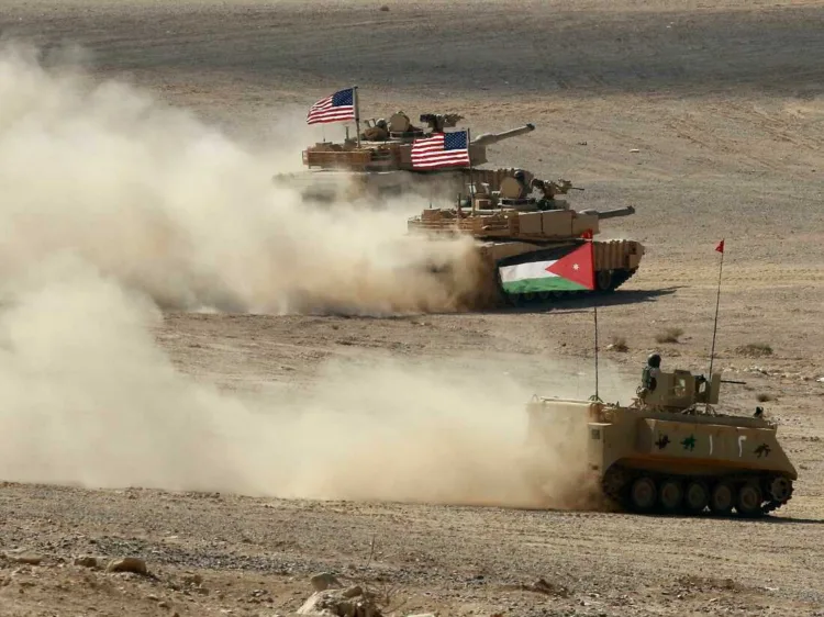 A Jordanian APC and US tanks take part in the "Eager Lion" multinational military manuever, in the Al-Zarqa governorate, some 85km northeast of the Jordanian capital Amman, on September 14, 2022. - The United States, Jordan, and 28 partner nations are taking part in the multinational military exercise, from September 4 to 15, 2022, representing one of the largest military exercises in the region, and designed to exchange military expertise and improve interoperability among partner nations. (Photo by Khalil MAZRAAWI / AFP) (Photo by KHALIL MAZRAAWI/AFP via Getty Images)