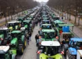 People stand beside tractors, as German farmers take part in a protest against the cut of vehicle tax subsidies, near the Brandenburg Gate in Berlin, Germany, December 18, 2023. REUTERS/Christian Mang