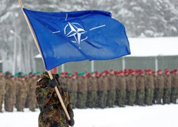 A soldier carries the NATO flag during German Minister of Defence Ursula von der Leyen's visit to German troops deployed as part of NATO enhanced Forward Presence (eFP) battle group in Rukla military base, Lithuania February 4, 2019. REUTERS/Ints Kalnins
