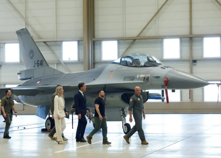 Ukrainian President Volodymyr Zelenskiy and Dutch Prime Minister Mark Rutte walk near an F-16, in Eindhoven, Netherlands, August 20, 2023. REUTERS/Piroschka van de Wouw