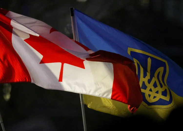FILE PHOTO: A Canadian flag and a Ukrainian flag with the tryzub are seen during a rally to mark the one year anniversary of Russia’s invasion of Ukraine at the Canadian Museum for Human Rights in Winnipeg, Manitoba, Canada on February 24, 2023. REUTERS/Shannon VanRaes