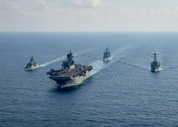 FILE PHOTO: Royal Australian Navy guided-missile frigate HMAS Parramatta (FFH 154) (L) sails with U.S. Navy Amphibious assault ship USS America (LHA 6), Ticonderoga-class guided-missile cruiser USS Bunker Hill (CG 52) and Arleigh-Burke class guided missile destroyer USS Barry (DDG 52) in the South China Sea, April 18, 2020. Picture taken April 18, 2020.   Petty Officer 3rd Class Nicholas Huynh/U.S. Navy/Handout via REUTERS    ATTENTION EDITORS - THIS IMAGE HAS BEEN SUPPLIED BY A THIRD PARTY.    To match Special Report AUSTRALIA-CHINA/RELATIONS/File Photo