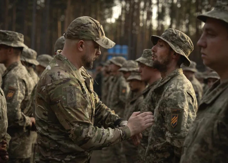 ARCHIVO - Soldados recién reclutados celebran el final de su instrucción en una base militar cerca de Kiev, Ucrania, el 25 de septiembre de 2023. Ucrania redujo el miércoles 3 de abril de 2024 la edad de reclutamiento de los 27 a los 25 años, en un intento de cubrir la falta de tropas para combatir a Rusia. (AP Foto/Efrem Lukatsky, Archivo)