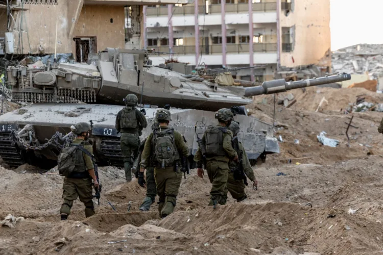 Israeli soldiers walk through rubble, amid the ongoing ground invasion against Palestinian Islamist group Hamas in the northern Gaza Strip, November 8, 2023. REUTERS/Ronen Zvulun