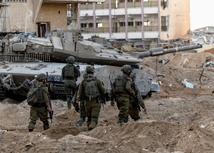 Israeli soldiers walk through rubble, amid the ongoing ground invasion against Palestinian Islamist group Hamas in the northern Gaza Strip, November 8, 2023. REUTERS/Ronen Zvulun