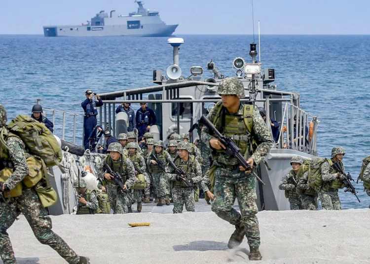 FILE - In this May 9, 2018, file photo, Philippine and U.S. Marines storm the beach during an amphibious landing exercise at the two-week joint U.S.-Philippines military exercise dubbed "Balikatan 34-2018" at the Naval Education and Training Command in Zambales province which is facing the South China Sea in northwestern Philippines. U.S. and Philippine forces began their largest annual military exercises since President Rodrigo Duterte came to power with a vow to scale back America's military presence in the country. (AP Photo/Bullit Marquez, File)