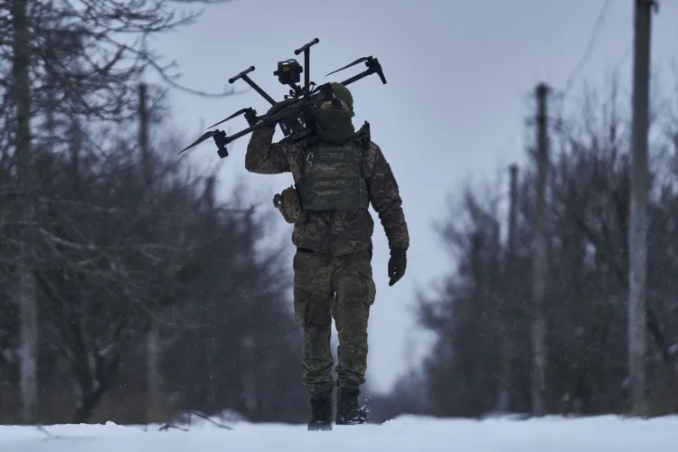 FILE -  A Ukrainian soldier carries a drone close to the frontline near Avdiivka, Donetsk region, Ukraine, Friday, Feb. 17, 2023. Ukrainian government is launching a new initiative meant to streamline and promote innovation on drones and other technologies that have become critical in the country's fight against Russia, by bringing together state, military, and private sector developers working on defense issues. (AP Photo/Libkos, File)