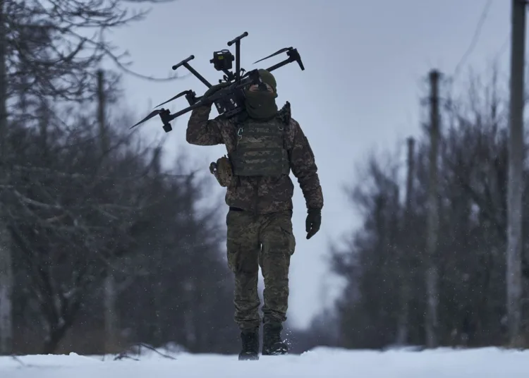 FILE - A Ukrainian soldier carries a drone close to the frontline near Avdiivka, Donetsk region, Ukraine, Friday, Feb. 17, 2023. Ukrainian government is launching a new initiative meant to streamline and promote innovation on drones and other technologies that have become critical in the country's fight against Russia, by bringing together state, military, and private sector developers working on defense issues. (AP Photo/Libkos, File)