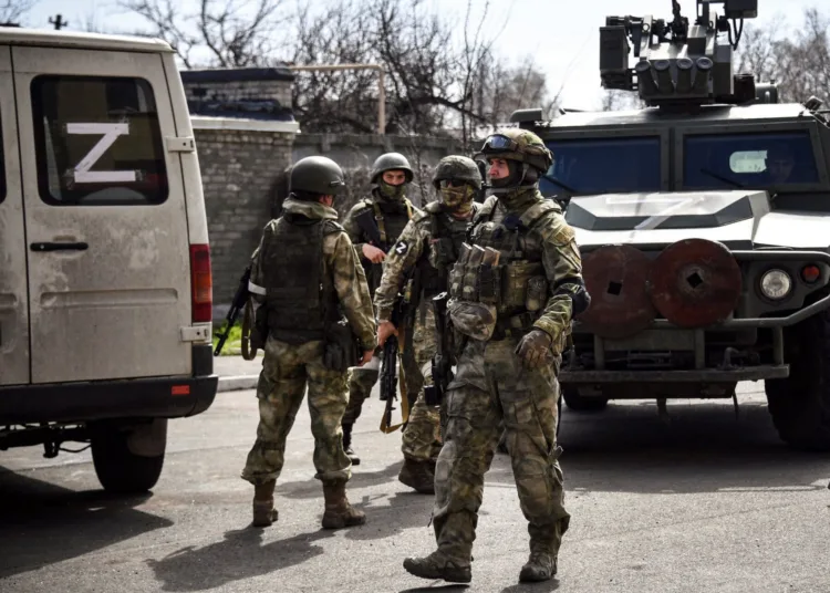 TOPSHOT - Russian soldiers patrol a street on April 11, 2022, in Volnovakha in the Donetsk region. The picture was taken during a trip organized by the Russian military. (Photo by Alexander NEMENOV / AFP) (Photo by ALEXANDER NEMENOV/AFP via Getty Images)